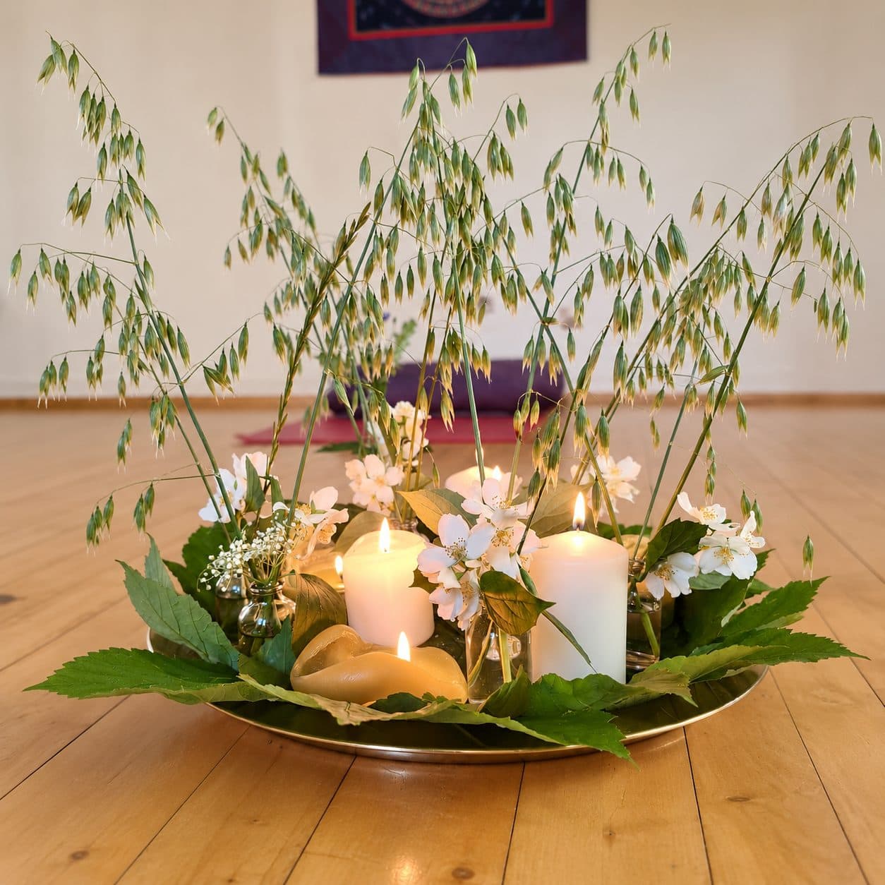 Blumen- und Kerzengesteck auf einem Holzboden in einem Seminarraum.
